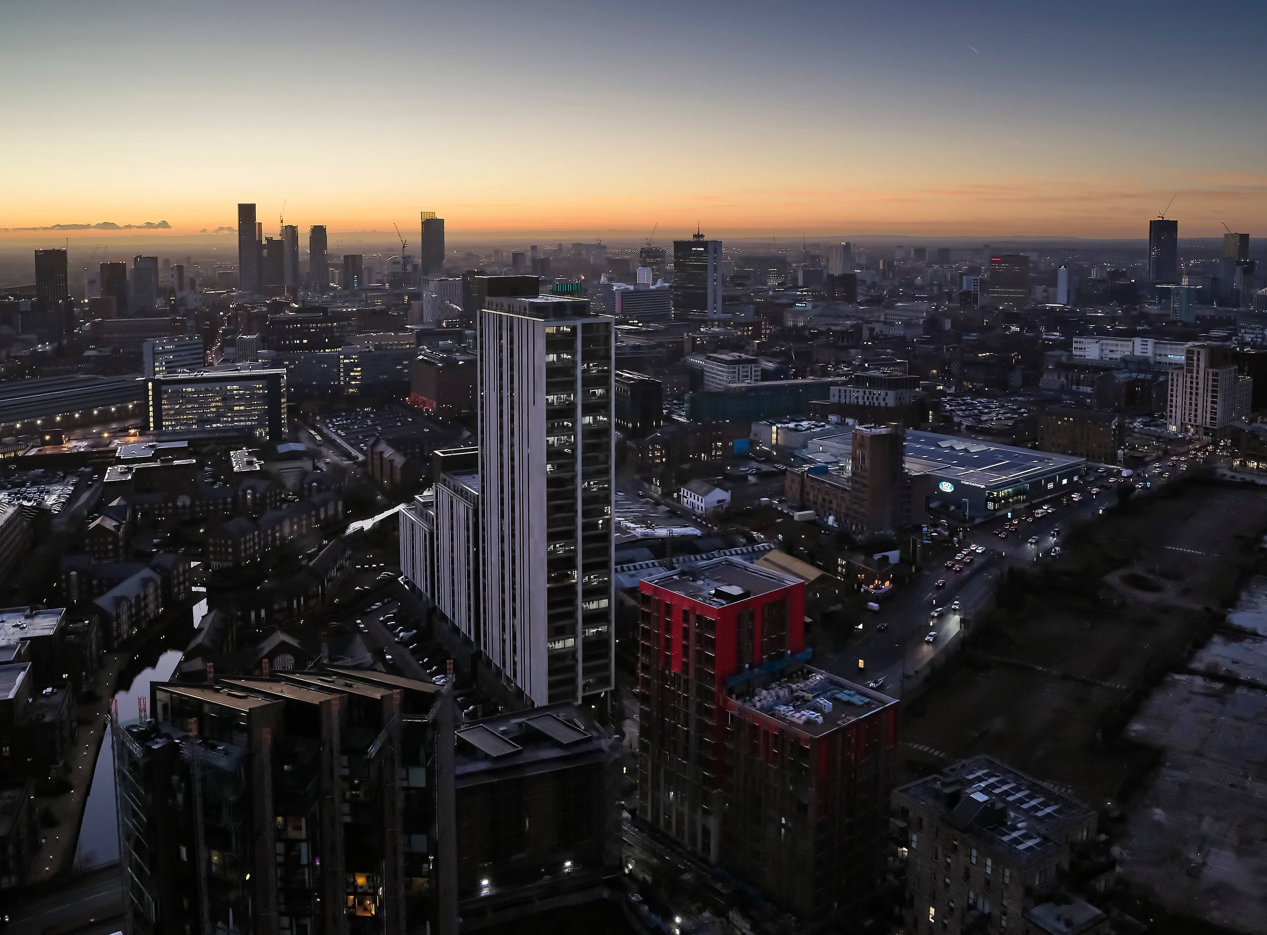 Landscape night time image of Manchester City Centre with buildings in the forefront.